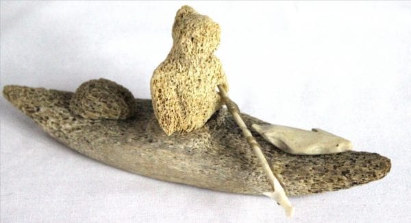 Inuit whalebone carving of hunter in kayak by William Pigalak