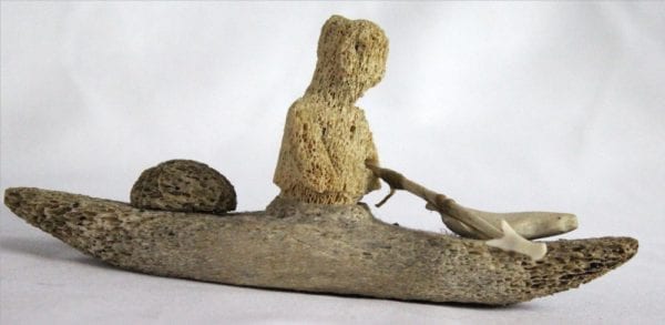 Inuit whalebone carving of hunter in kayak by William Pigalak