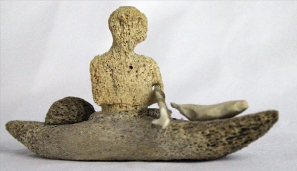 Inuit whalebone carving of hunter in kayak by William Pigalak