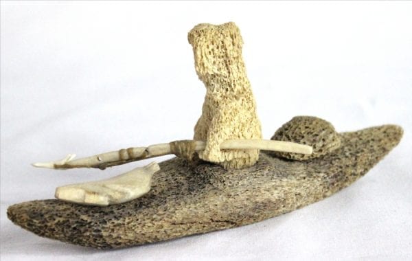 Inuit whalebone carving of hunter in kayak by William Pigalak