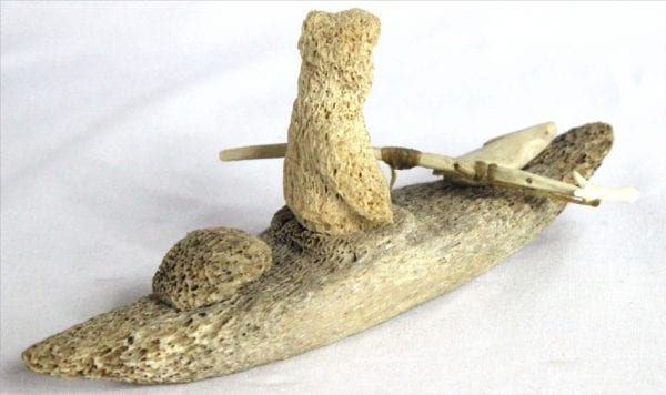 Inuit whalebone carving of hunter in kayak by William Pigalak