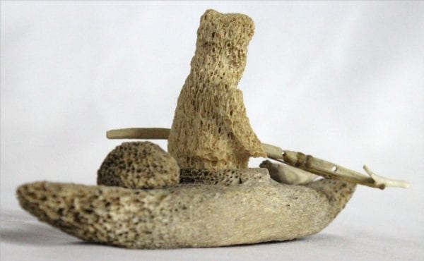 Inuit whalebone carving of hunter in kayak by William Pigalak