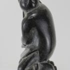 Carving of kneeling Inuk eating fish