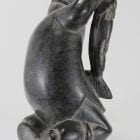 Carving of kneeling Inuk eating fish