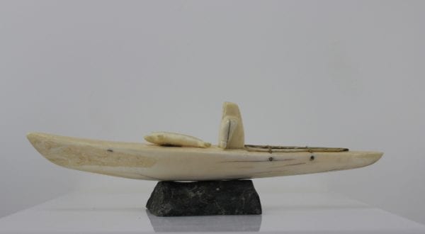 Ivory hunter and kayak carved by an unknown Inuit artist. Thought to be from Pangnirtung.