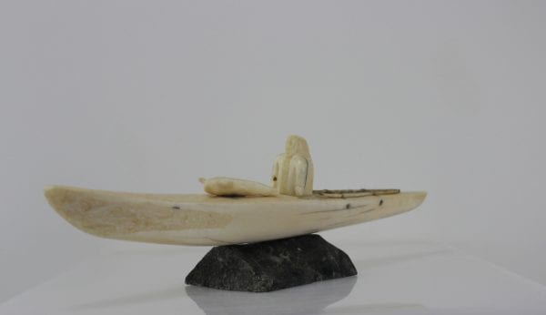 Ivory hunter and kayak carved by an unknown Inuit artist. Thought to be from Pangnirtung.