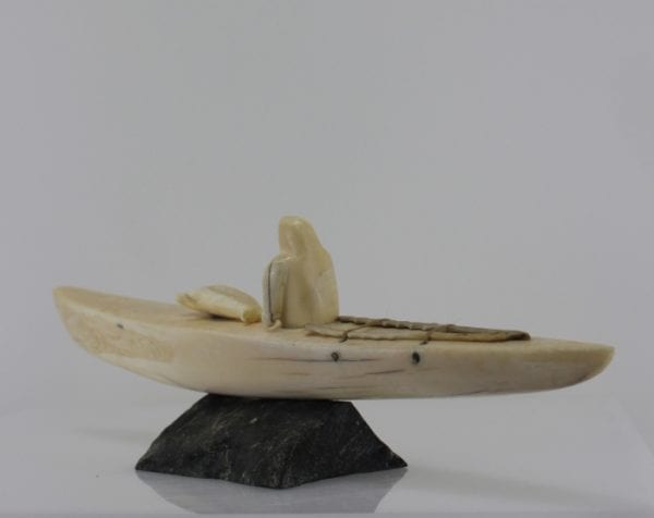 Ivory hunter and kayak carved by an unknown Inuit artist. Thought to be from Pangnirtung.