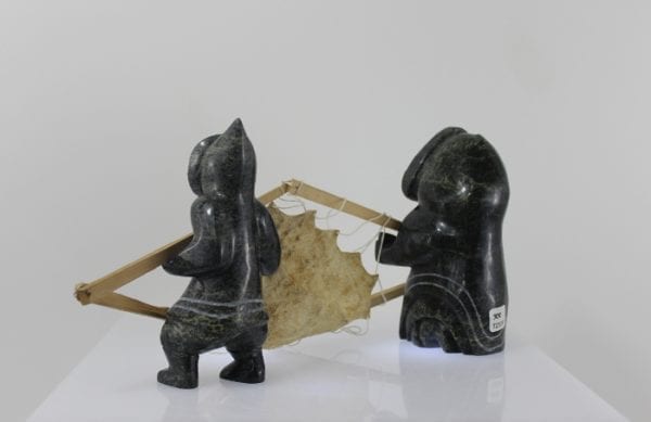 Drying skin, a three piece carving by Mosesee Pootoogook