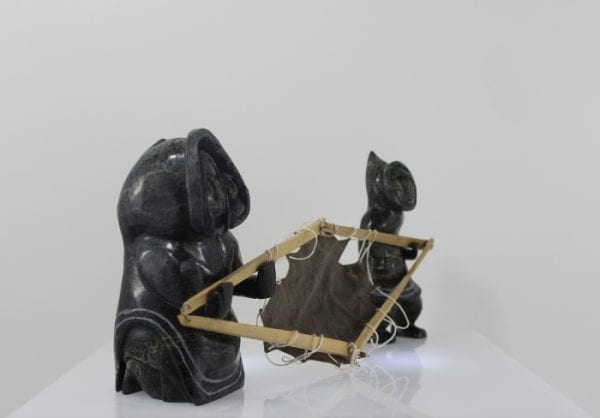 Drying skin, a three piece carving by Mosesee Pootoogook